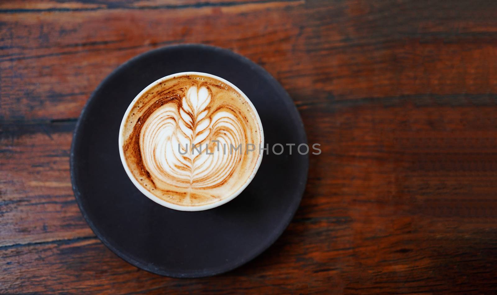 Top view of hot latte or cappuccino coffee on rustic wooden tabl by nuchylee