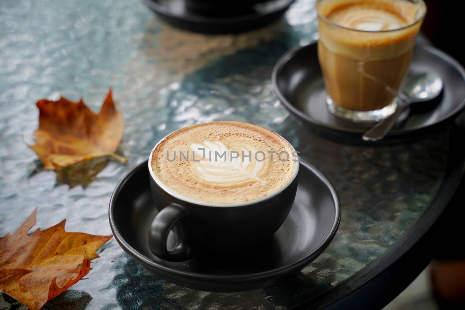 Hot cup of coffee latte and flat white with autumn leaves on the by nuchylee
