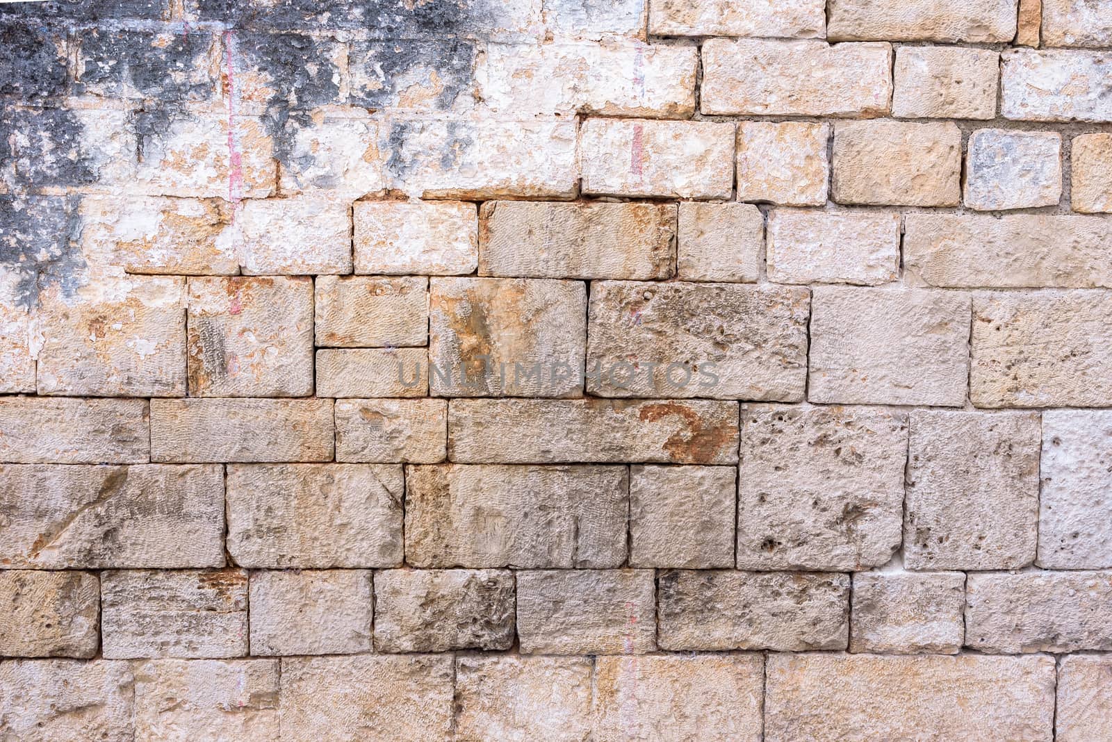 Background or texture made of brick wall with remains of plaster