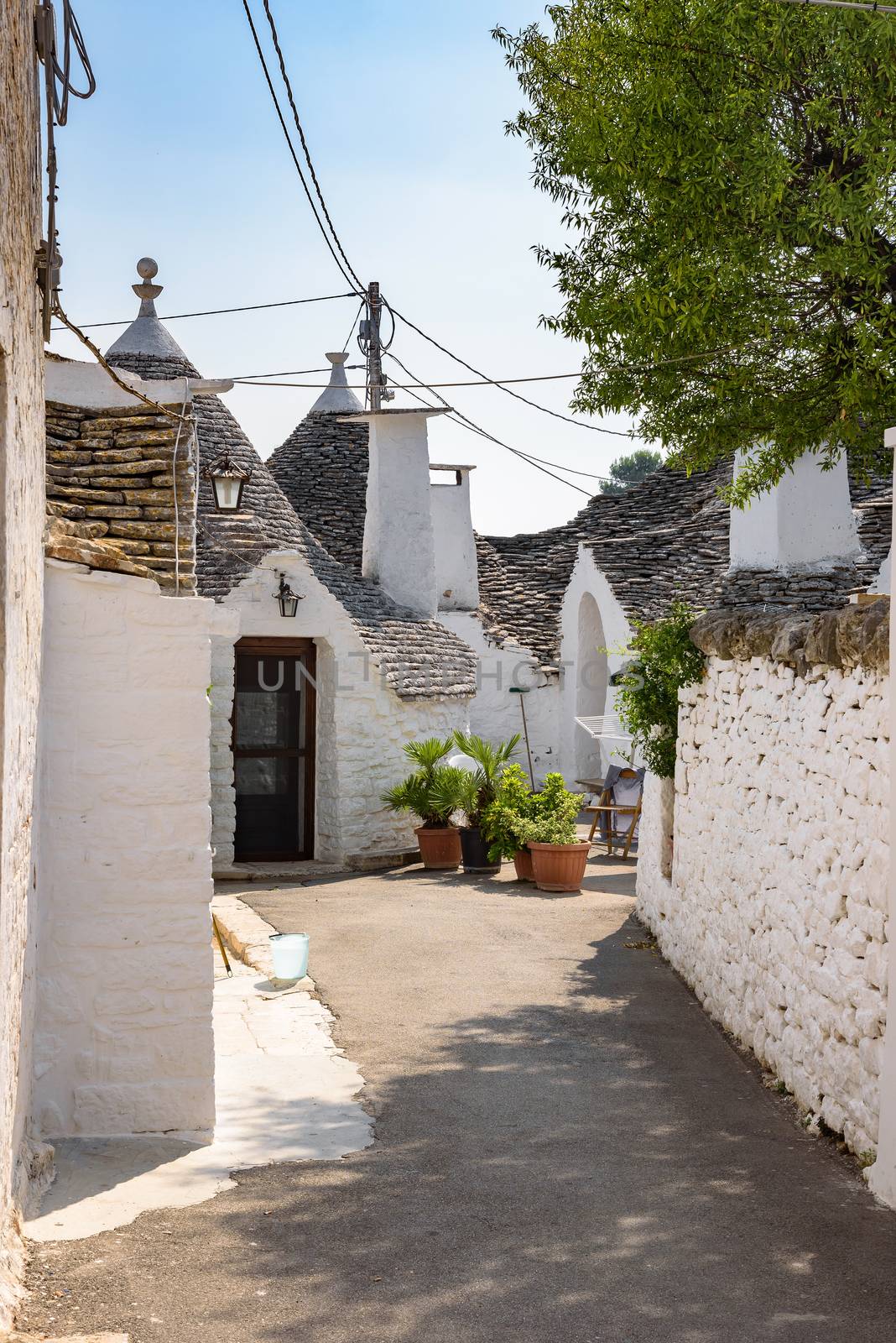 View of narrow picturesque street in Alberobello town, Apulia, Italy