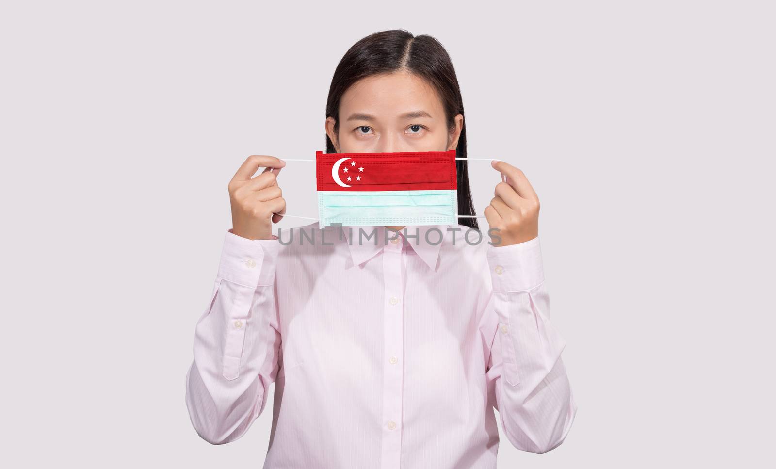 Asian woman wearing hygienic face mask painting Singapore flag to protect from the Coronavirus 2019 (COVID-19) infection outbreak situation, the virus originated from Wuhan, China.