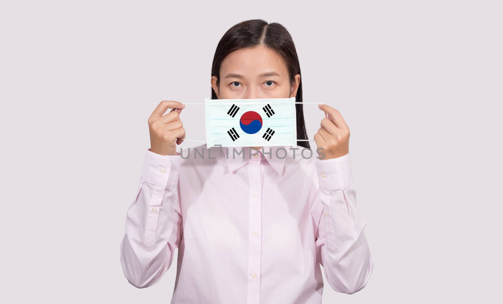 Asian woman wearing hygienic face mask painting South Korea flag to protect from the Coronavirus 2019 (COVID-19) infection outbreak situation, the virus originated from Wuhan, China.