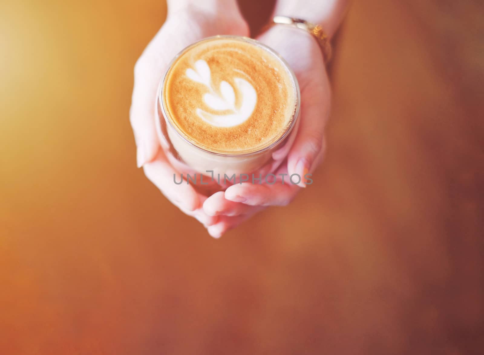Close up hands of barista woman holding cup of hot cappuccino coffee in the cafe, copy space