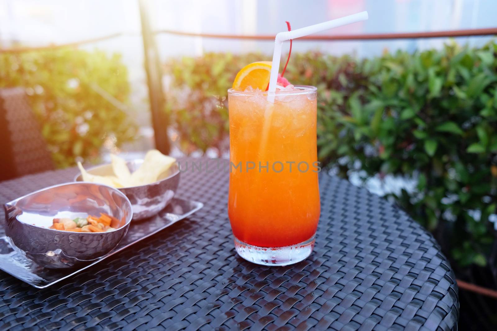 Iced cocktail glass and snack on the table in rooftop bar for ni by nuchylee