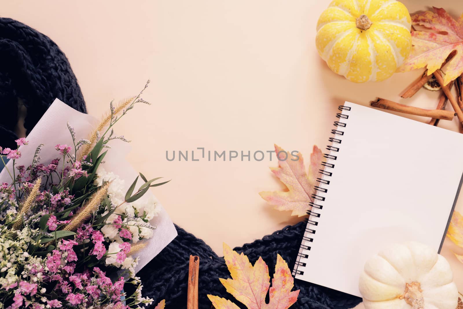 Flat lay style of autumn and thanksgiving with pumpkin, notebook, scarf, bouquet of flower and maple leaf, copy space