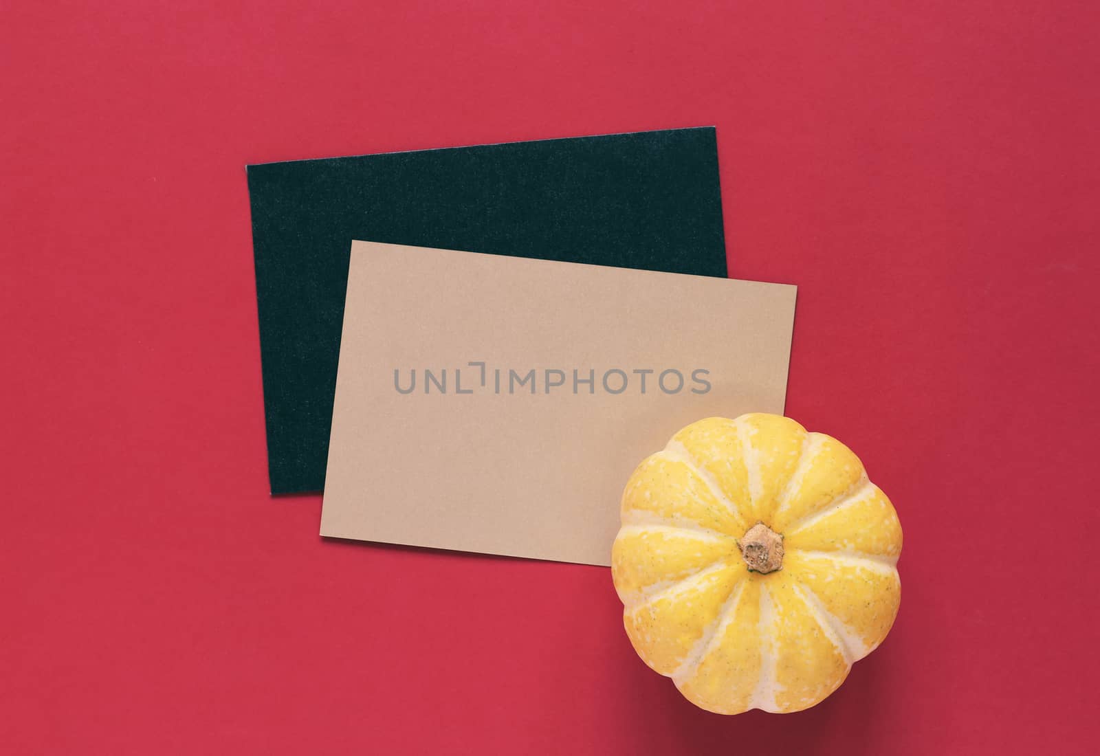 Yellow pumpkin on blank greeting card with red background, halloween or thanksgiving concept  