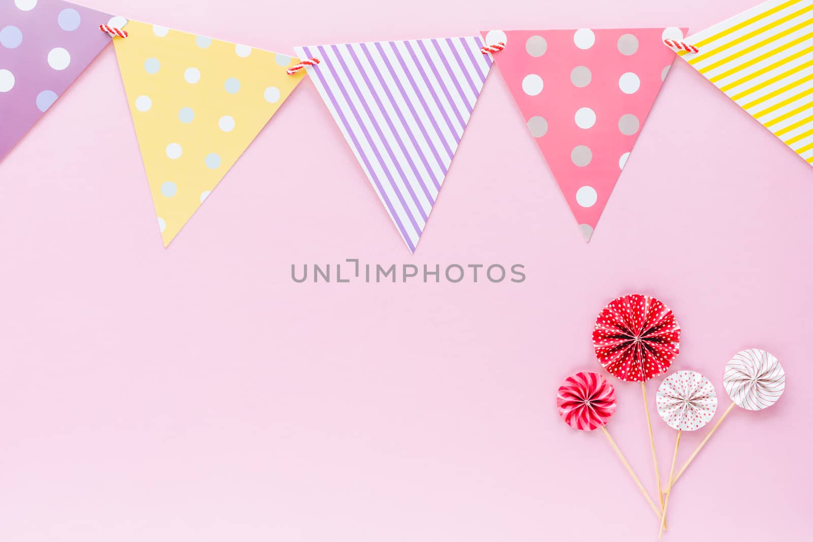 Colourful paper flag with red and white paper fan on pink background for party decoration