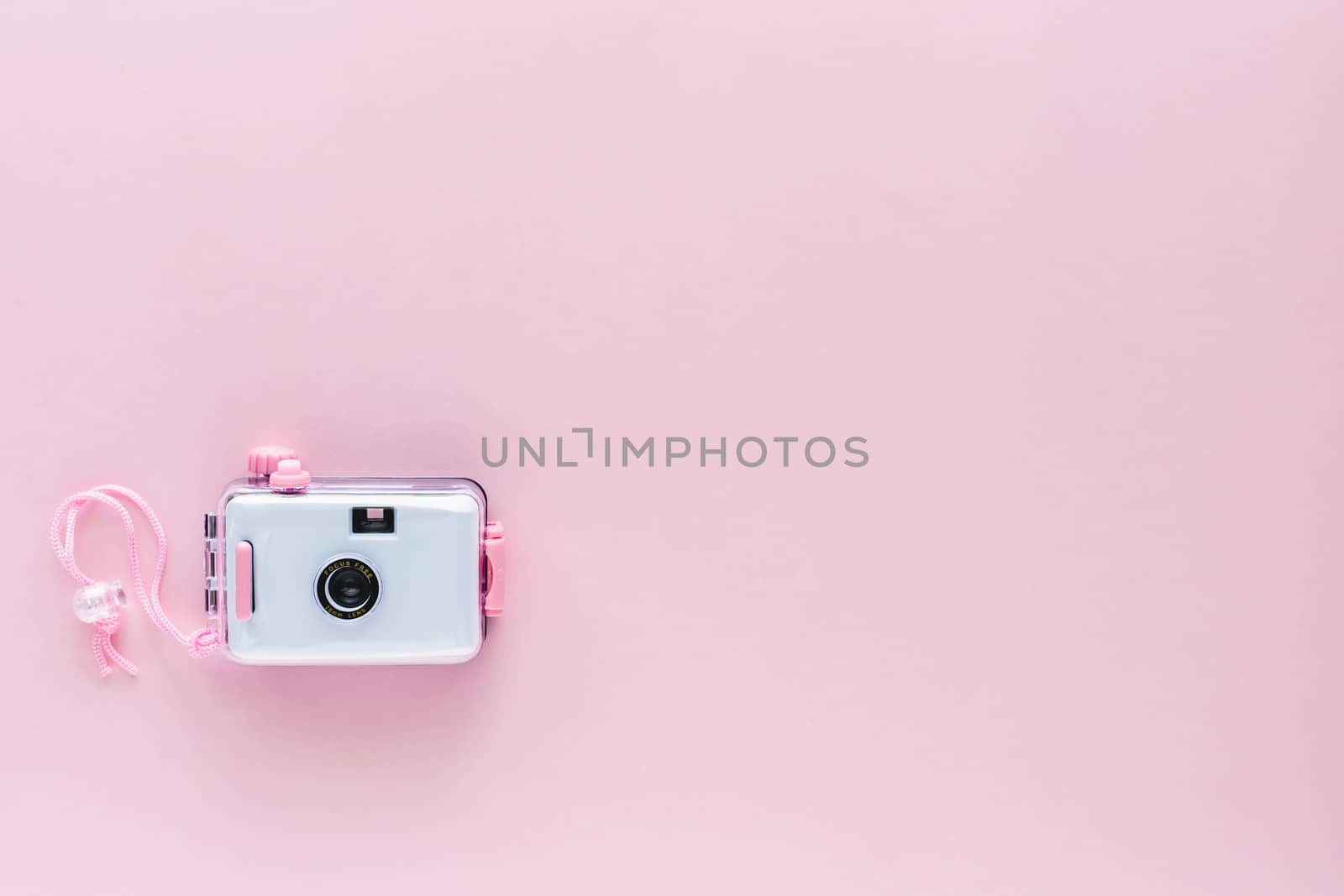 Camera waterproof toy on pink background with copy space