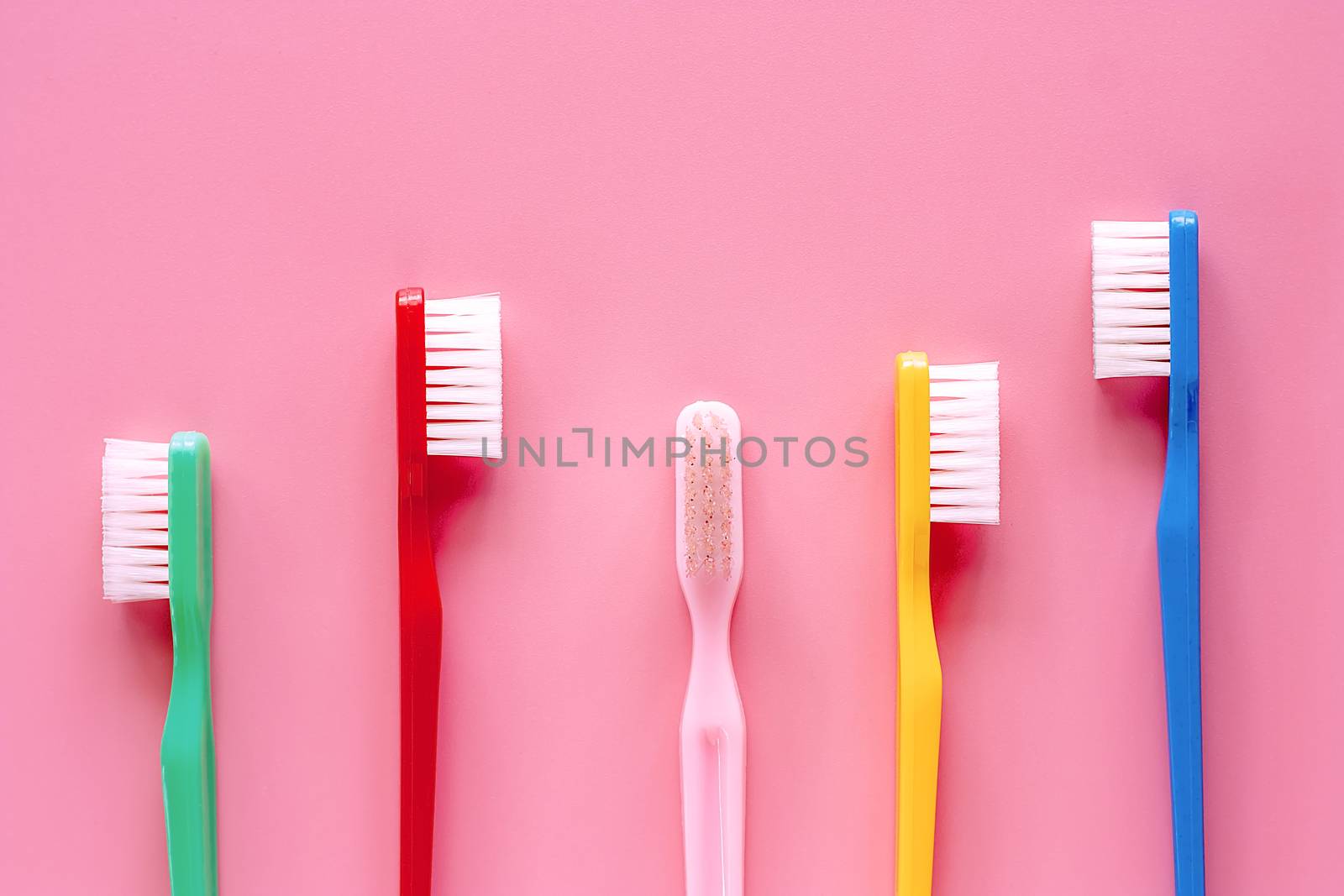 Toothbrush used for cleaning the teeth on pink background for dental care concept