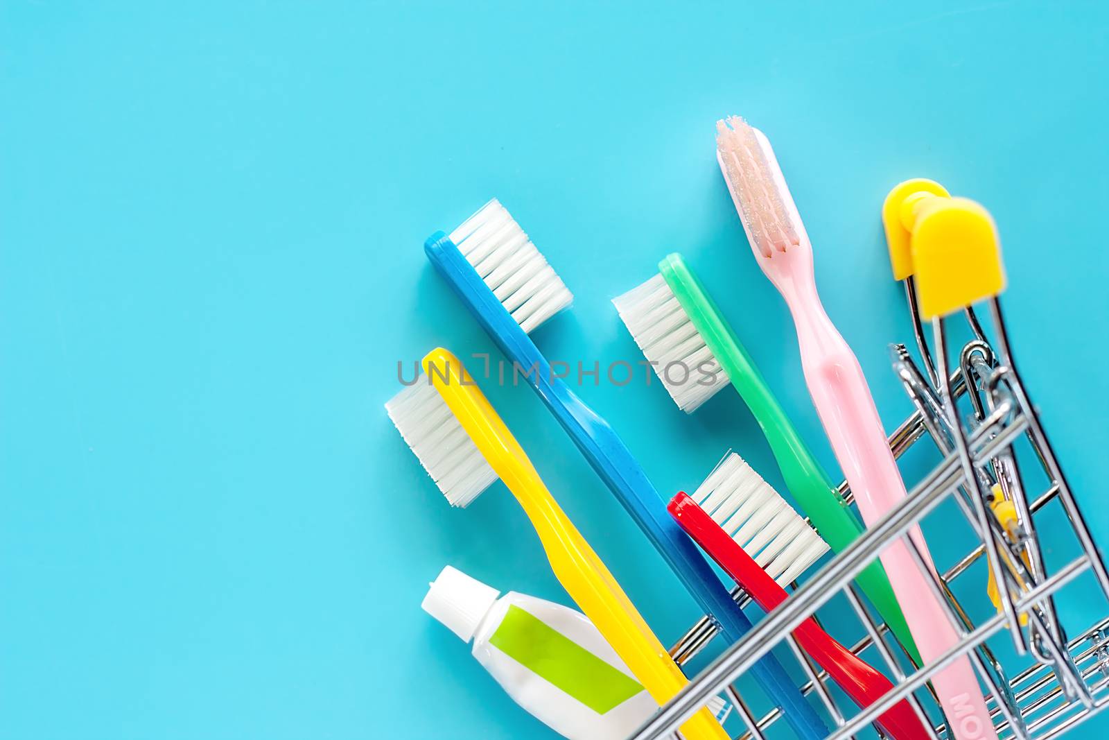 Shopping cart with toothbrush and toothpaste on blue background by iamnoonmai