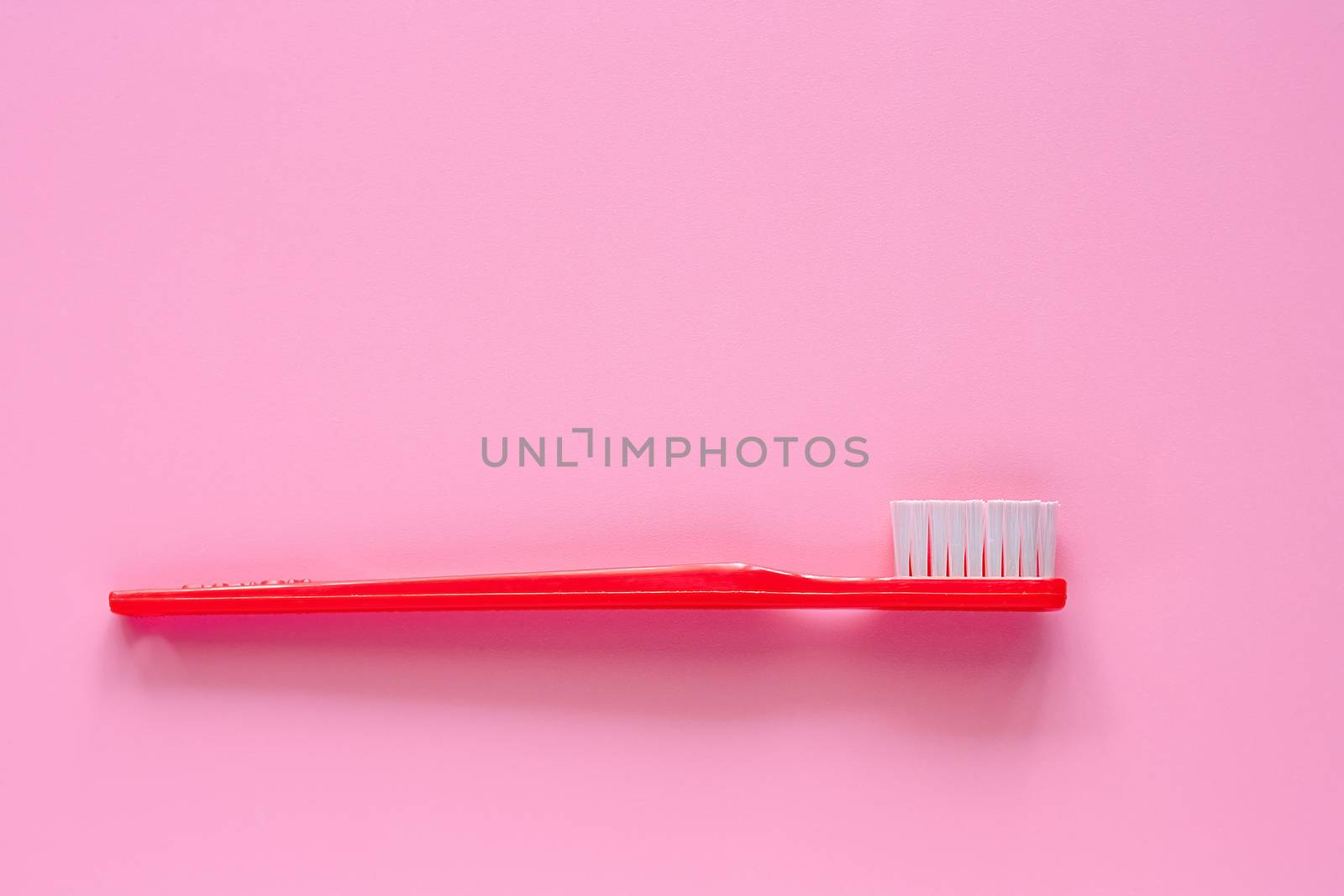 Toothbrush used for cleaning the teeth on pink background by iamnoonmai