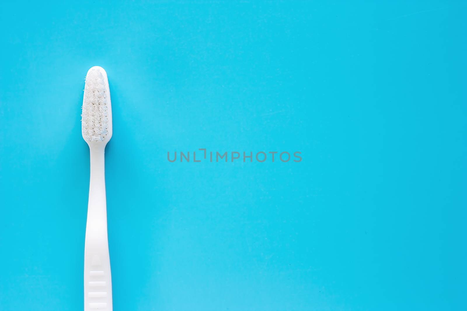 White toothbrush used for cleaning the teeth on blue background by iamnoonmai