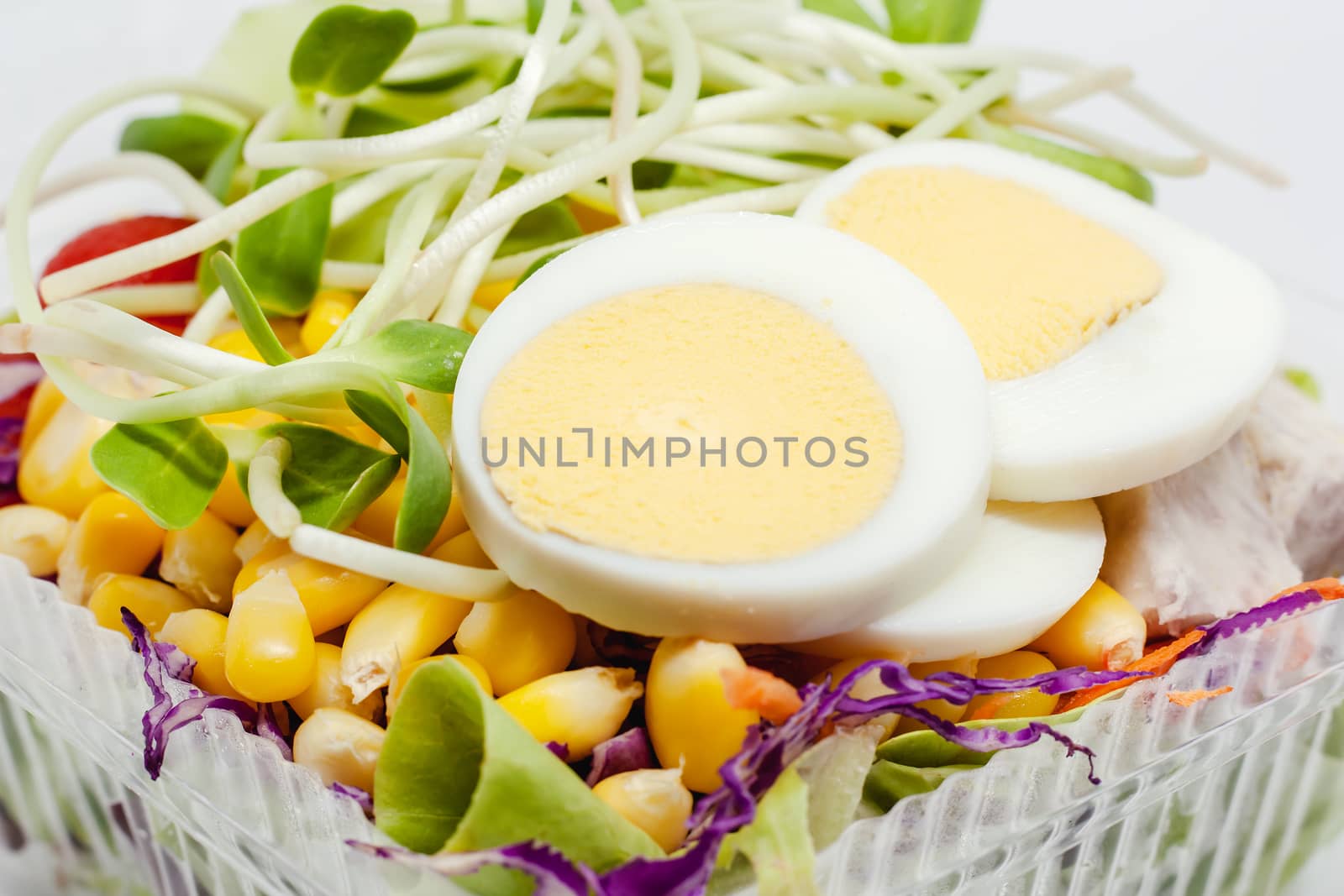 Close up of boiled chicken egg with fresh salad vegetable for healthy eating and diet food concept