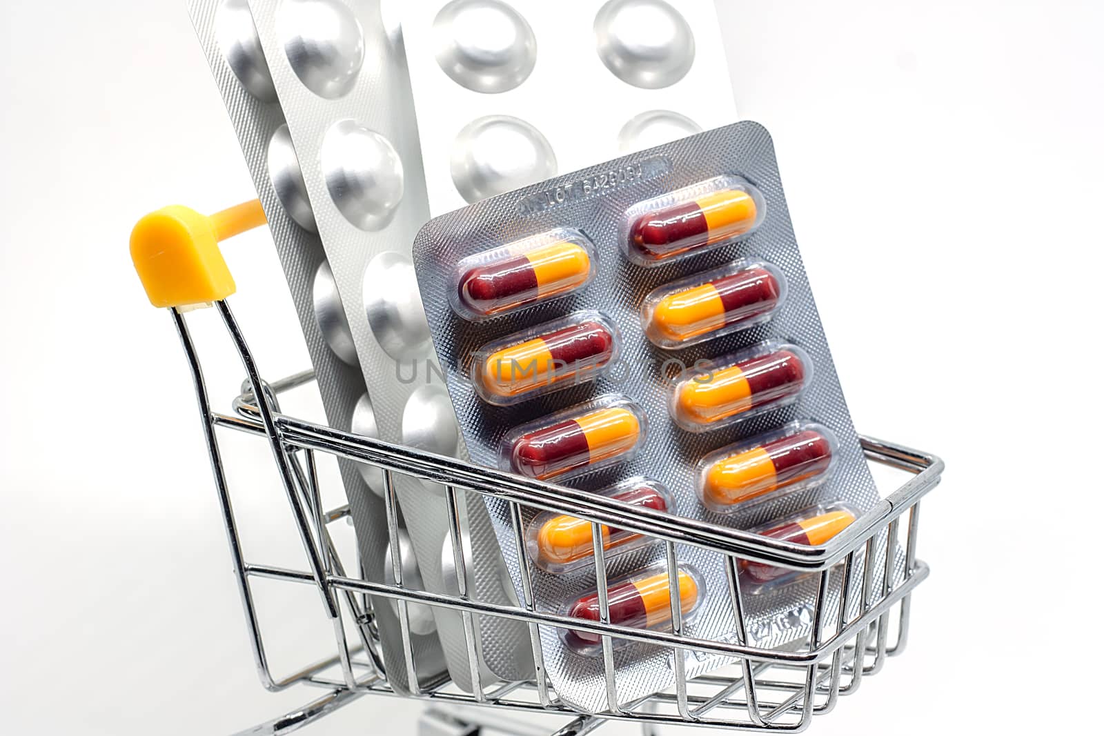 Medicine, pills, drug or tablets in a blister pack in shopping cart on white background for healthcare and medical concept