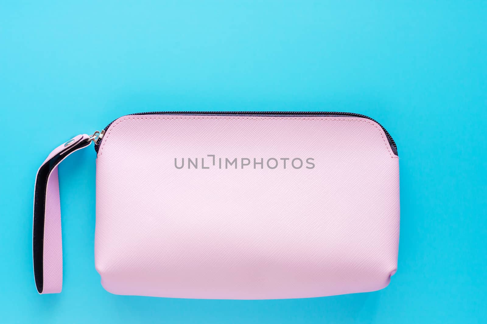 Pink lady leather bag on blue background for cosmetics and beauty concept