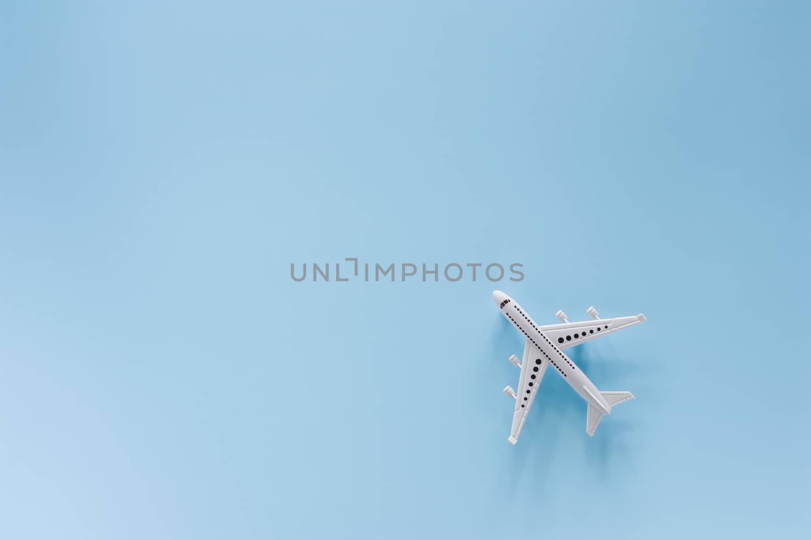 White airplane model on blue background for vehicle and transportation concept