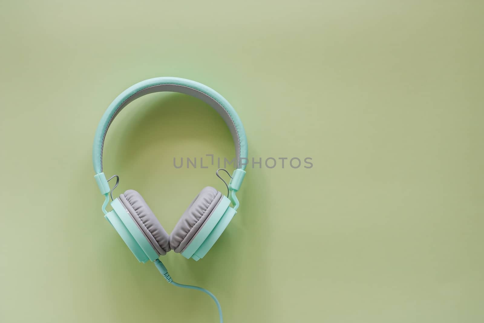 Headphones on green background for music and relaxation concept