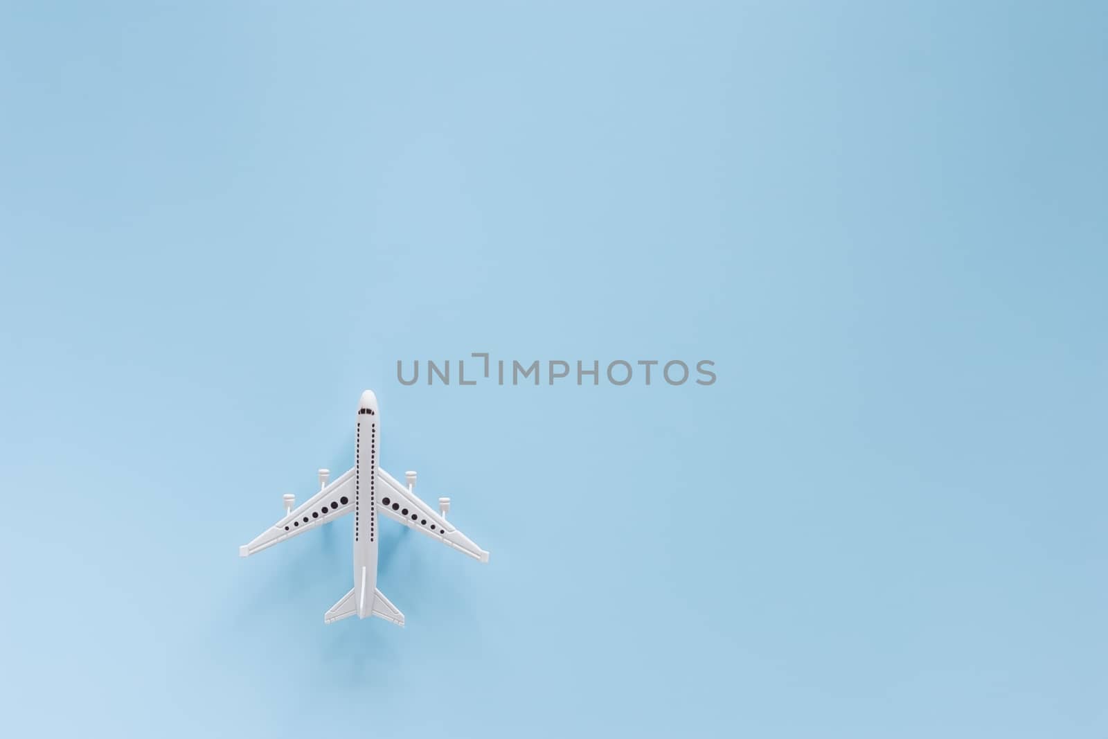 White airplane model on blue background for vehicle and transportation concept