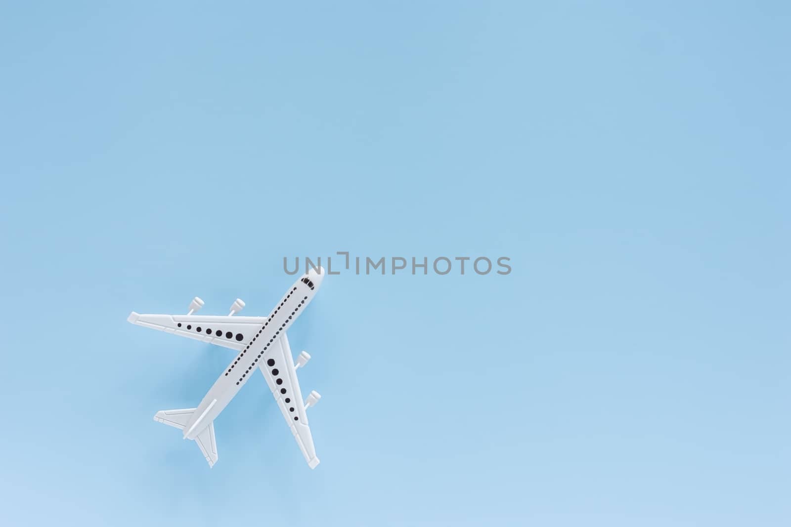 White airplane model on blue background for vehicle and transportation concept