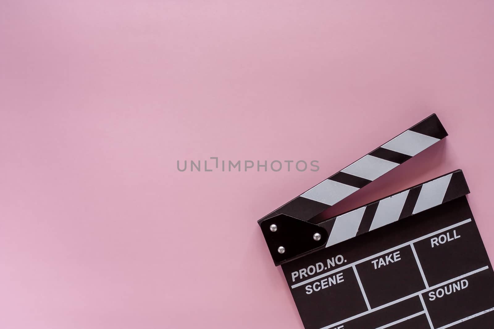 Movie clapper board on pink background for filming equipment