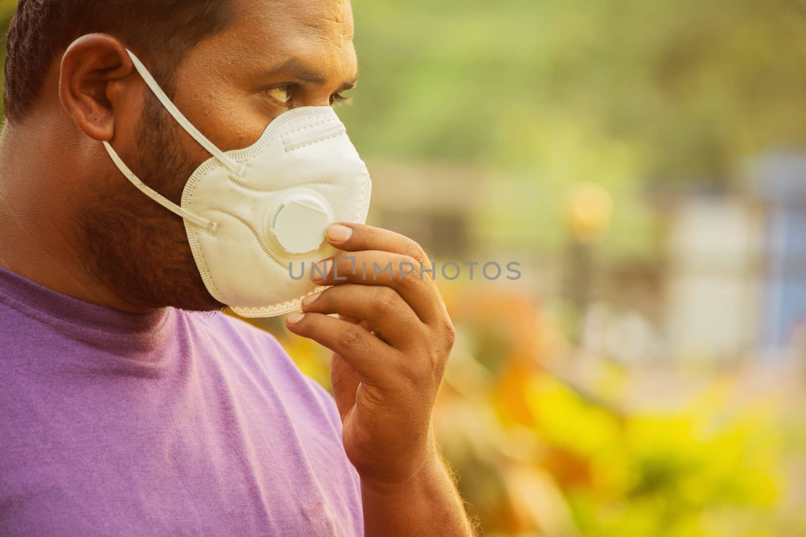 Asian man wearing the face mask due to air pollution - Young adult on park with Pollution mask - person protecting from air contamination by wearing mask. by lakshmiprasad.maski@gmai.com