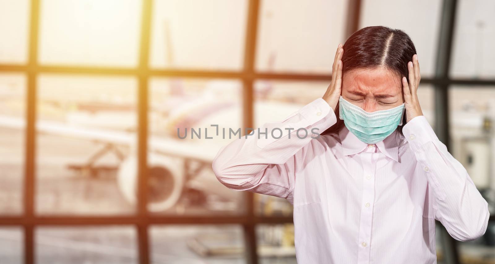 Asian tourist feeling sick, have a fever ,wearing hygienic face mask to prevent during travel time at the airport terminal for protect from the new Coronavirus 2019 infection outbreak situation