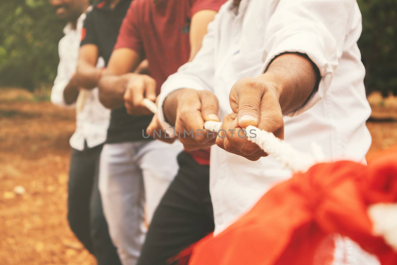 Close up of hands playing tug of war - Group of friends playing outdoor games in changing digital and technology world. by lakshmiprasad.maski@gmai.com