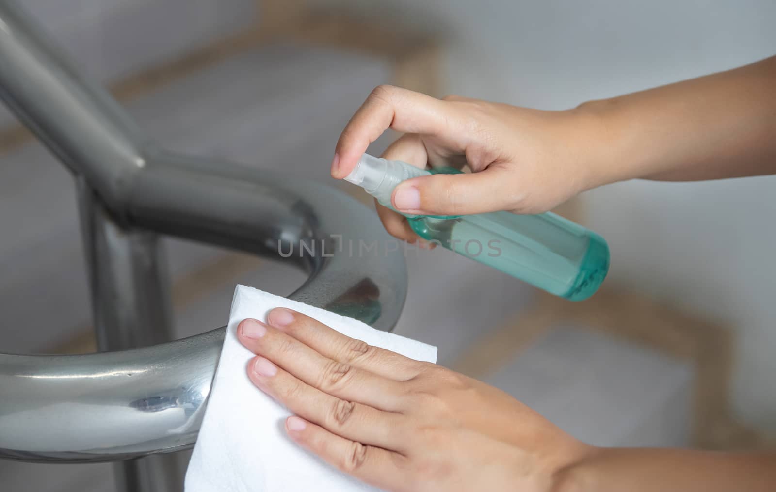 disinfect, sanitize, hygiene care. cleaning staff using alcohol spray on banister and frequently touched area for cleaning and disinfection, prevention of germs spreading during infections of COVID-19