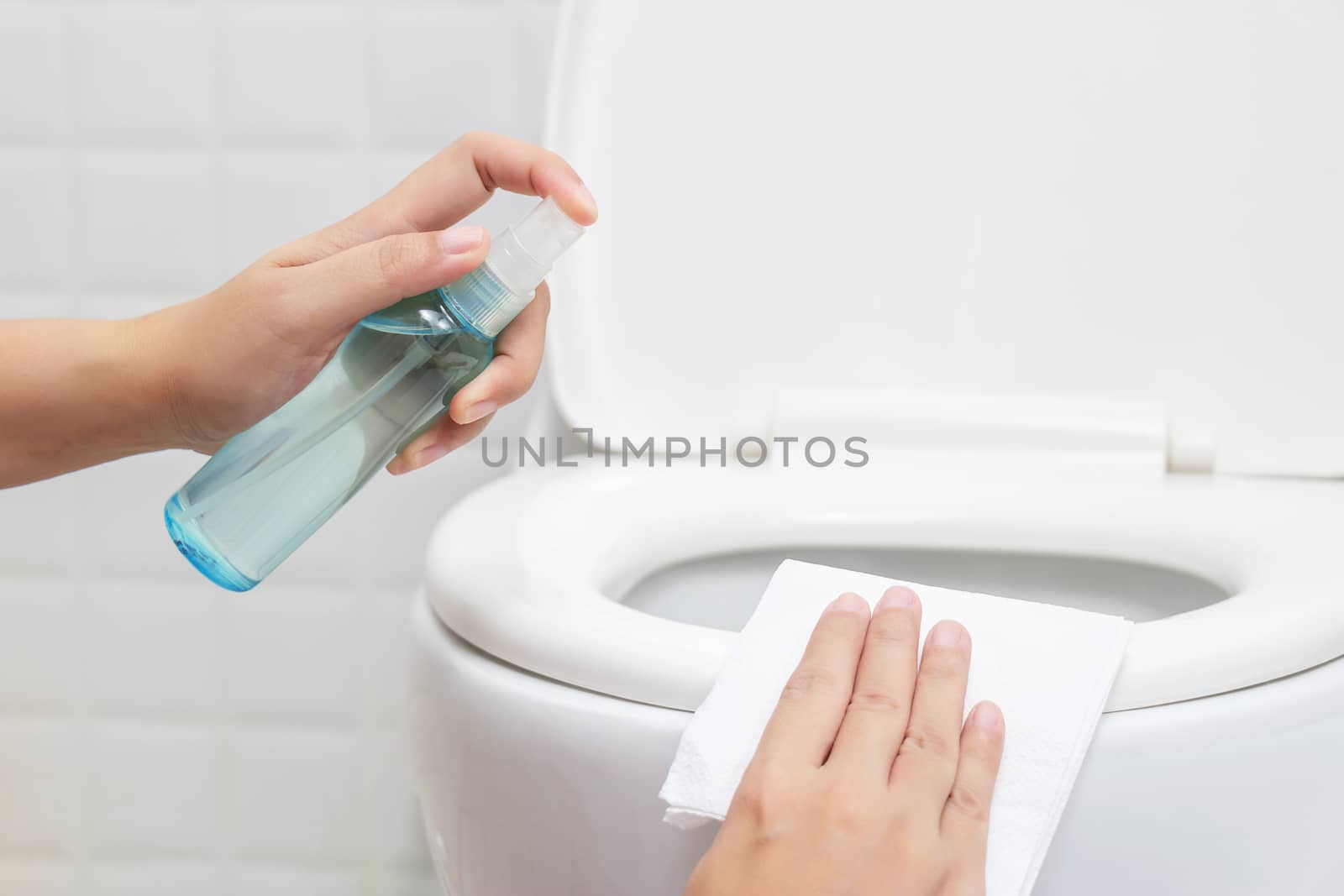 disinfect, sanitize, hygiene care. people using alcohol spray on toilet seat lid and frequently touched area for cleaning and disinfection, prevention of germs spreading during infections of COVID-19