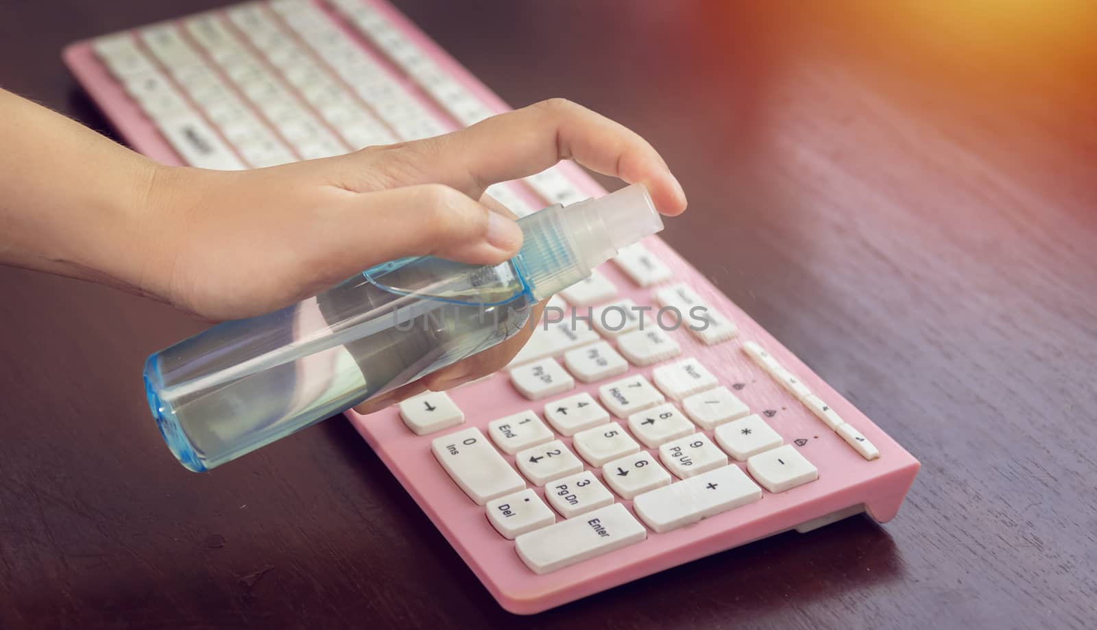 disinfect, sanitize, hygiene care. people using alcohol spray on computer keyboard and frequently touched area for cleaning and disinfection, prevention of germs spreading during infections of COVID-19