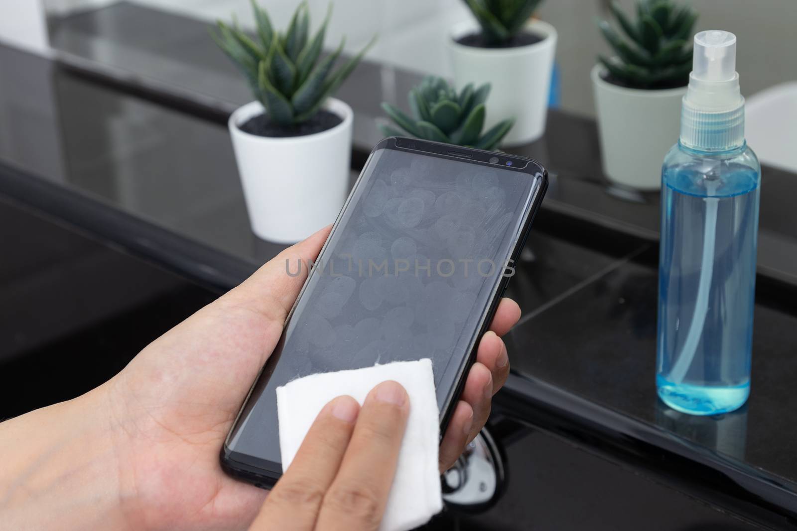 disinfect, sanitize, hygiene care. cleaning fingerprint on mobile phone touch screen for disinfection, prevention of germs spreading during infections of COVID-19 coronavirus