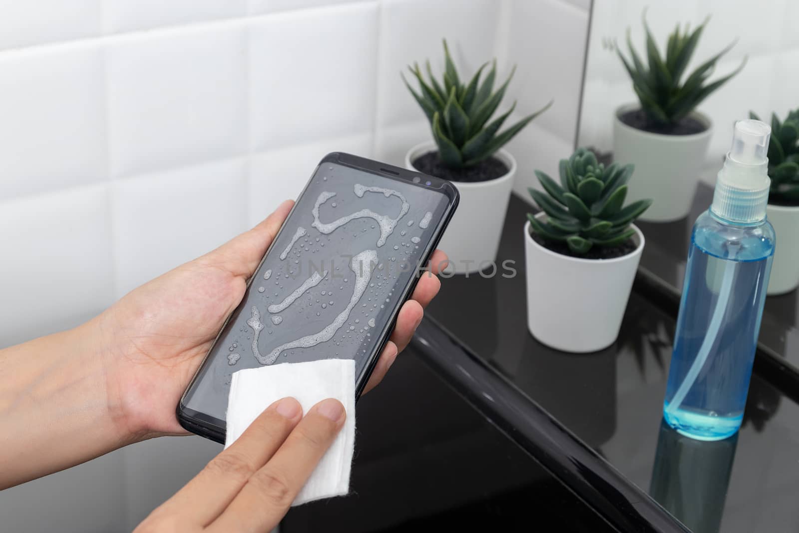 disinfect, sanitize, hygiene care. cleaning dirty stain on mobile phone touch screen for disinfection, prevention of germs spreading during infections of COVID-19 coronavirus