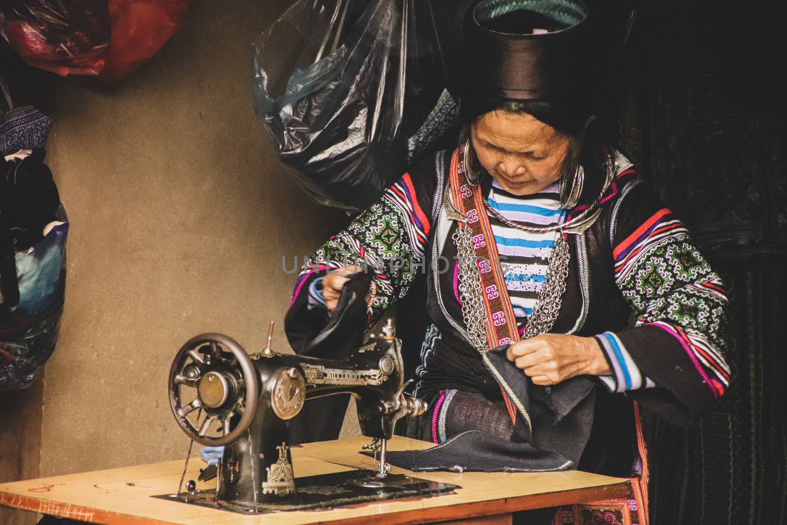 Editorial. A woman from the Black Hmong Tribe wearing traditional clothes and working at her shop in Sa pa, Vietnam