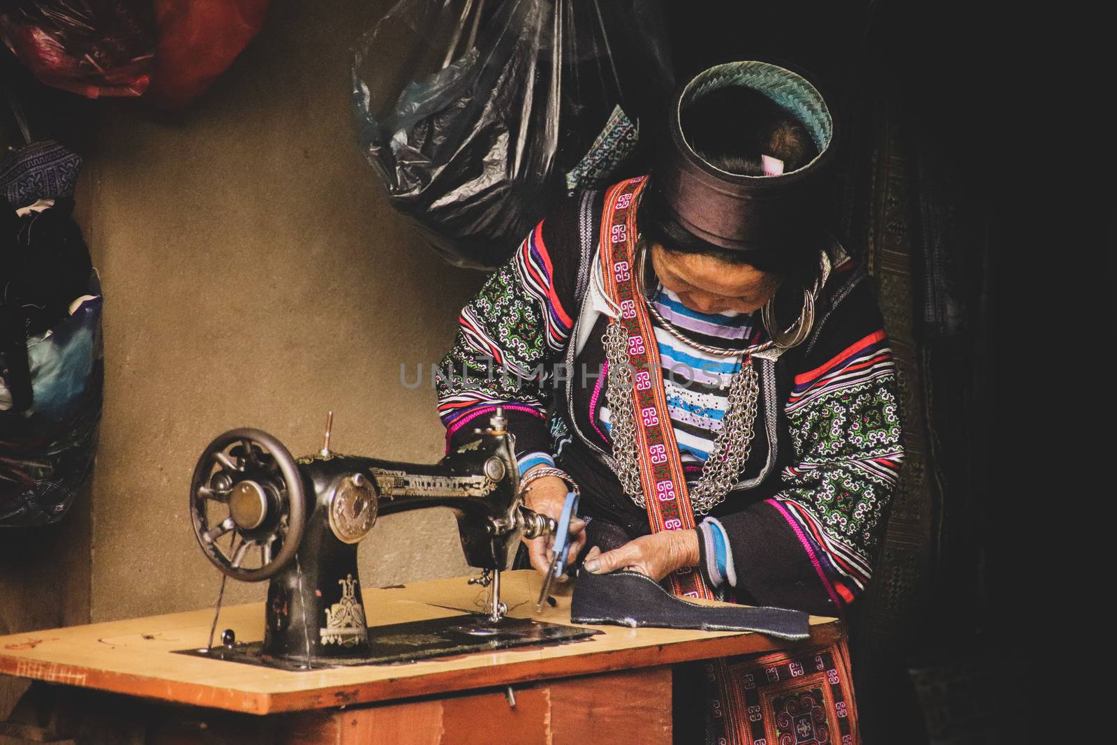 Editorial. A woman from the Black Hmong Tribe wearing traditional clothes and working at her shop in Sa pa, Vietnam