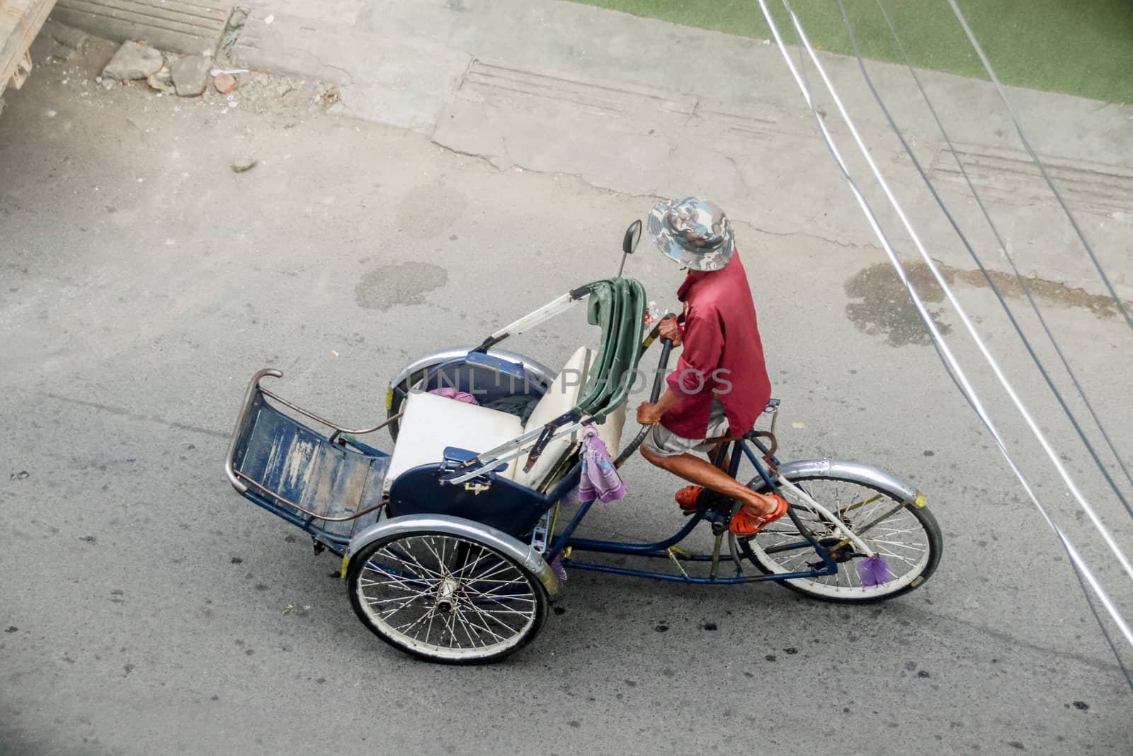 Editorial. A Cambodian Rickshaw driver looking for tourist to tour around the city of Phnom Phen, Cambodia