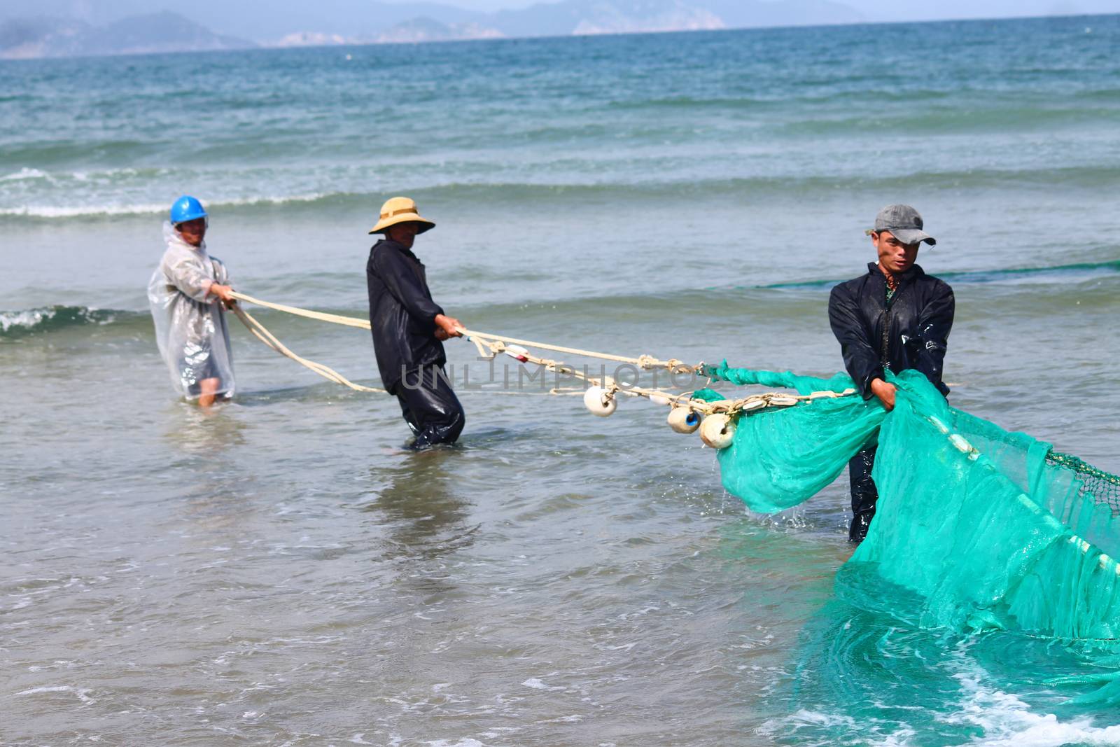 Editorial. Group of fishermen pulling on a fishing net by Sonnet15