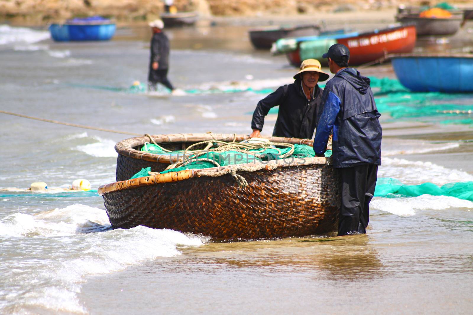 Editorial. Vietnamese fisherman putting the nets on a basket boat or thung cai in the fishing village of Quy Nhon, Vietnam