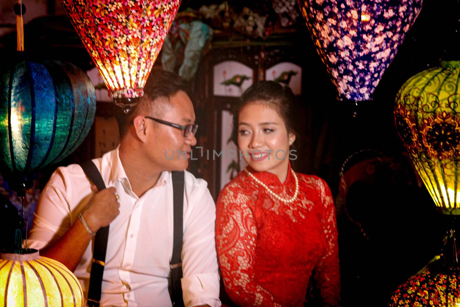Editorial, Vietnamese couple posing for a photo among the traditional lanterns during the Lantern Festival in Hoi an, Vietnam