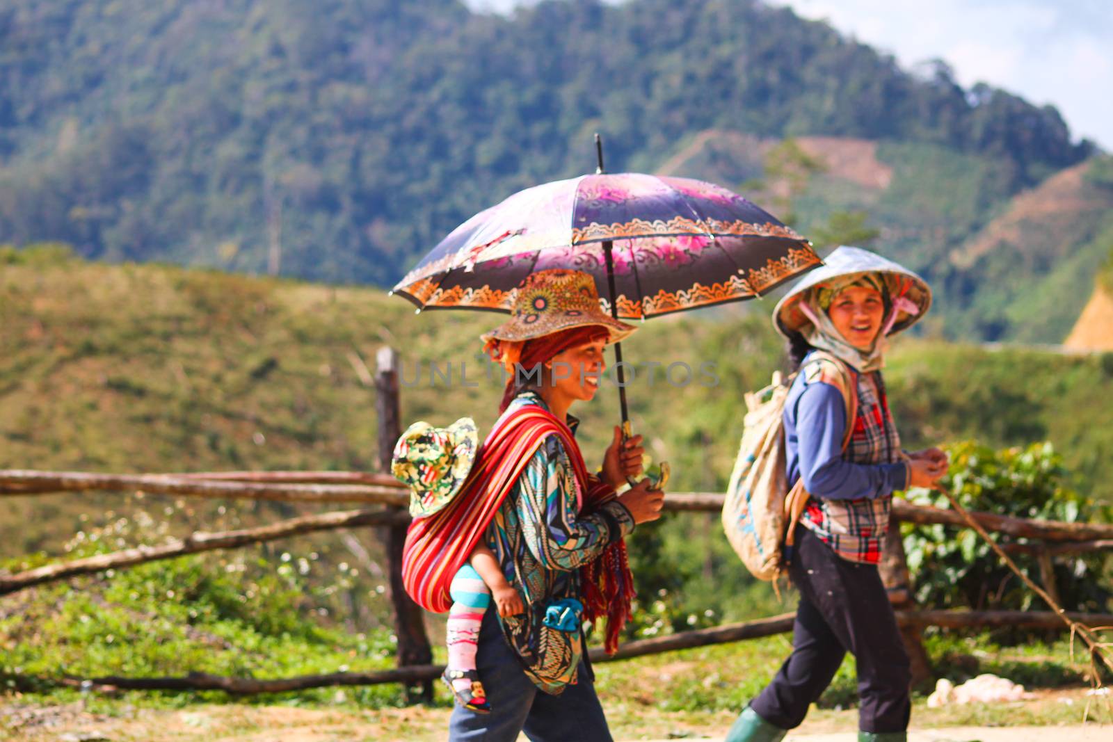 Editorial. Vietnamese women farmer walking back home from a full day of working in the Central Highlands of Vietnam