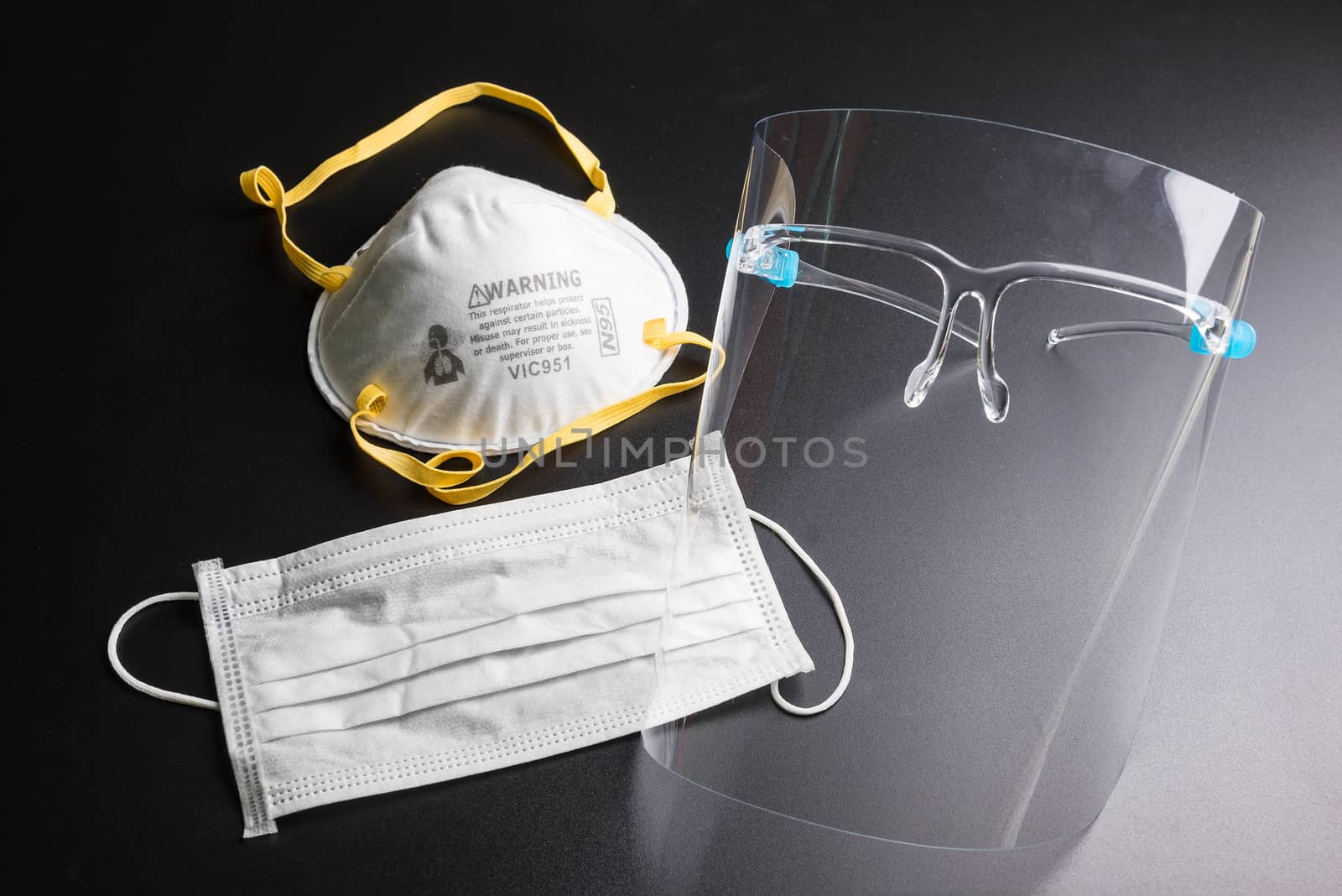 Face shield and Health mask on a black background. Pandemic COVID-19 virus and protection against coronavirus concept.Concepcion prevent diseases.