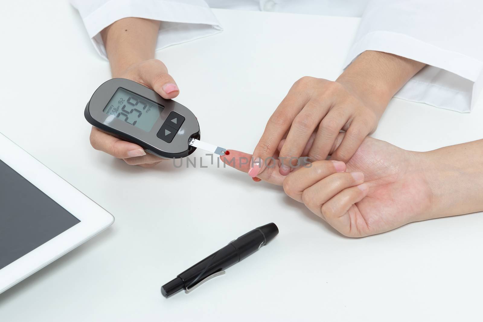 check diabetes. patient with diabetes let doctor put a drop of blood on a test strip into a meter for check blood sugar (glucose) levels results. health care concept 