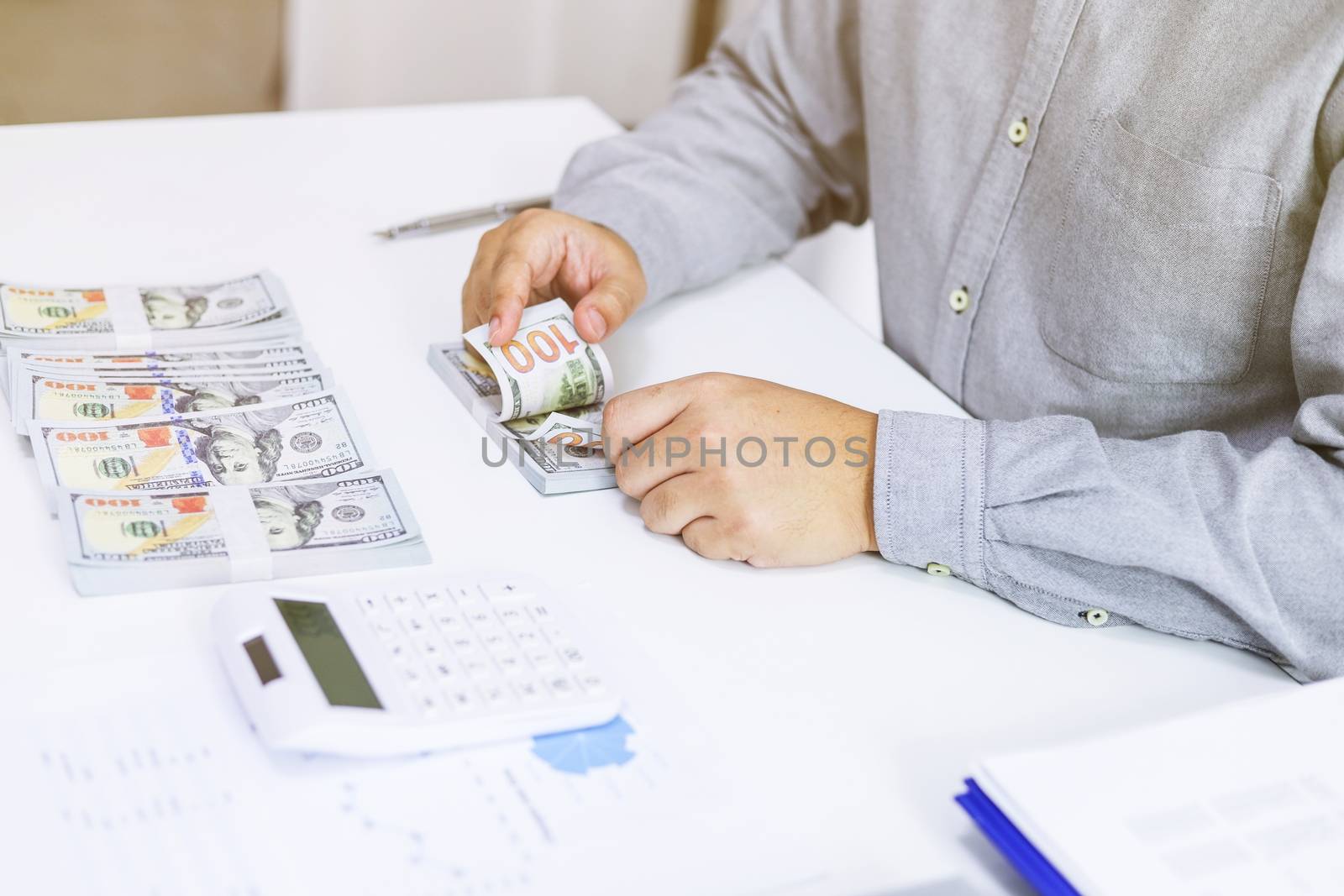 Businessman analyzing investment charts and pressing calculator buttons over documents. Accounting Concept