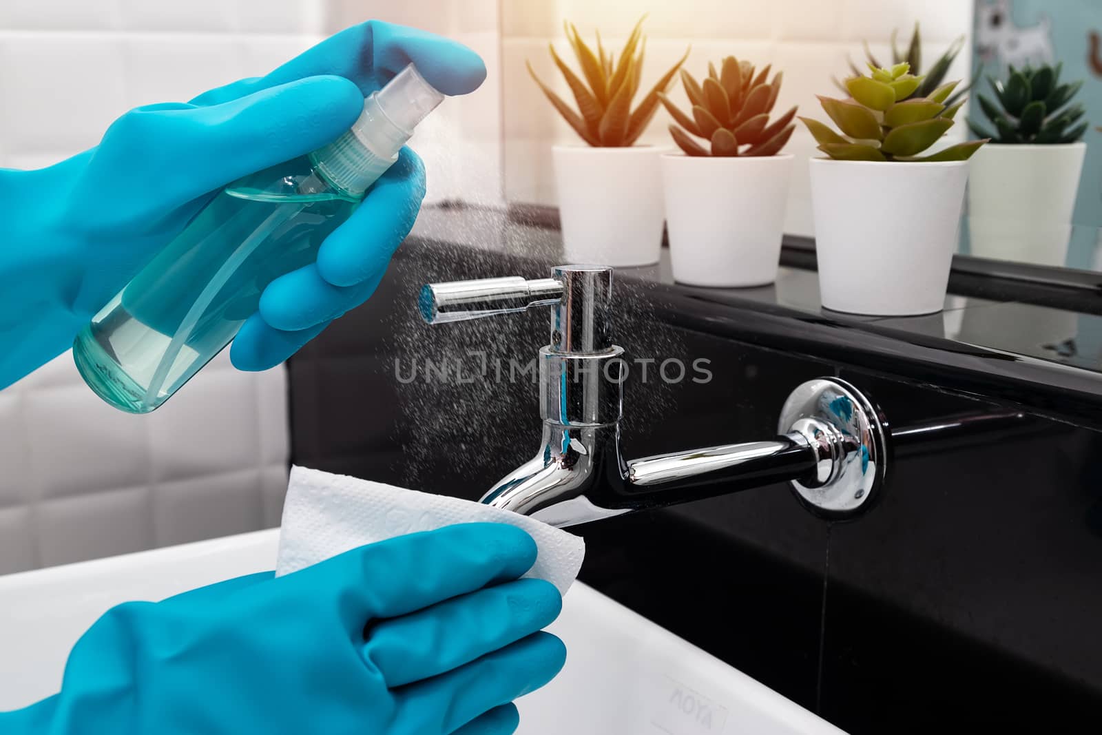disinfect, sanitize, hygiene care. cleaning staff using alcohol spray on faucet , hydrant and frequently touched area for cleaning and prevention of germs spreading during infections of COVID-19