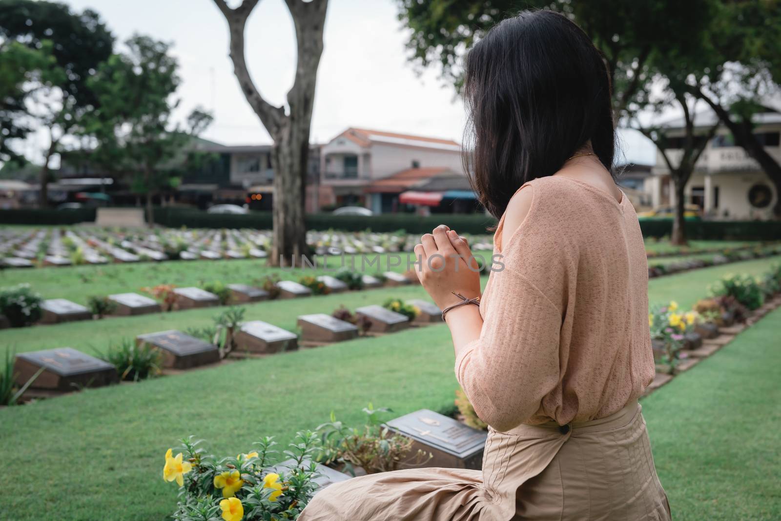 Close-Up of Religious Christian Woman Hands Clasped While Honoring and Praying to Military in War Cemetery. Teenager Woman in Expression Sadness and Pray for Soldier Prisoner of War in Tomb.