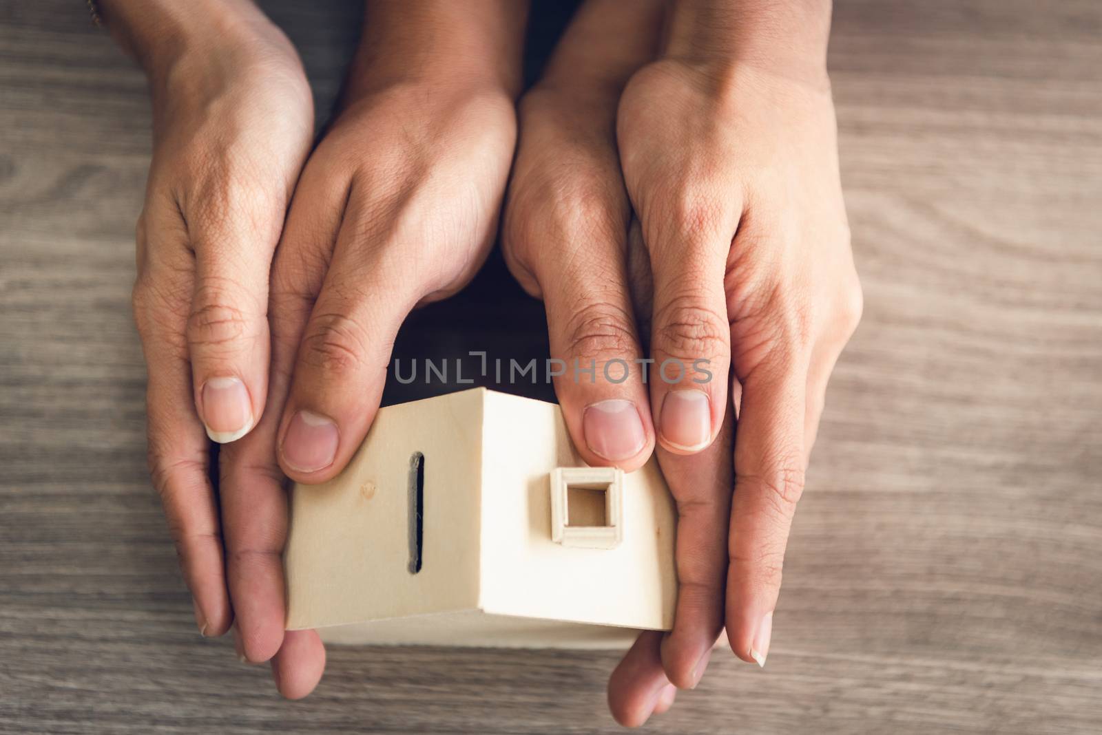 Couple Hands Holding Housing Model for Future Real Estate Saving, People Hand Joint to Protection Home Property Togetherness. House Insurance and Residential Loan Investment Concept.