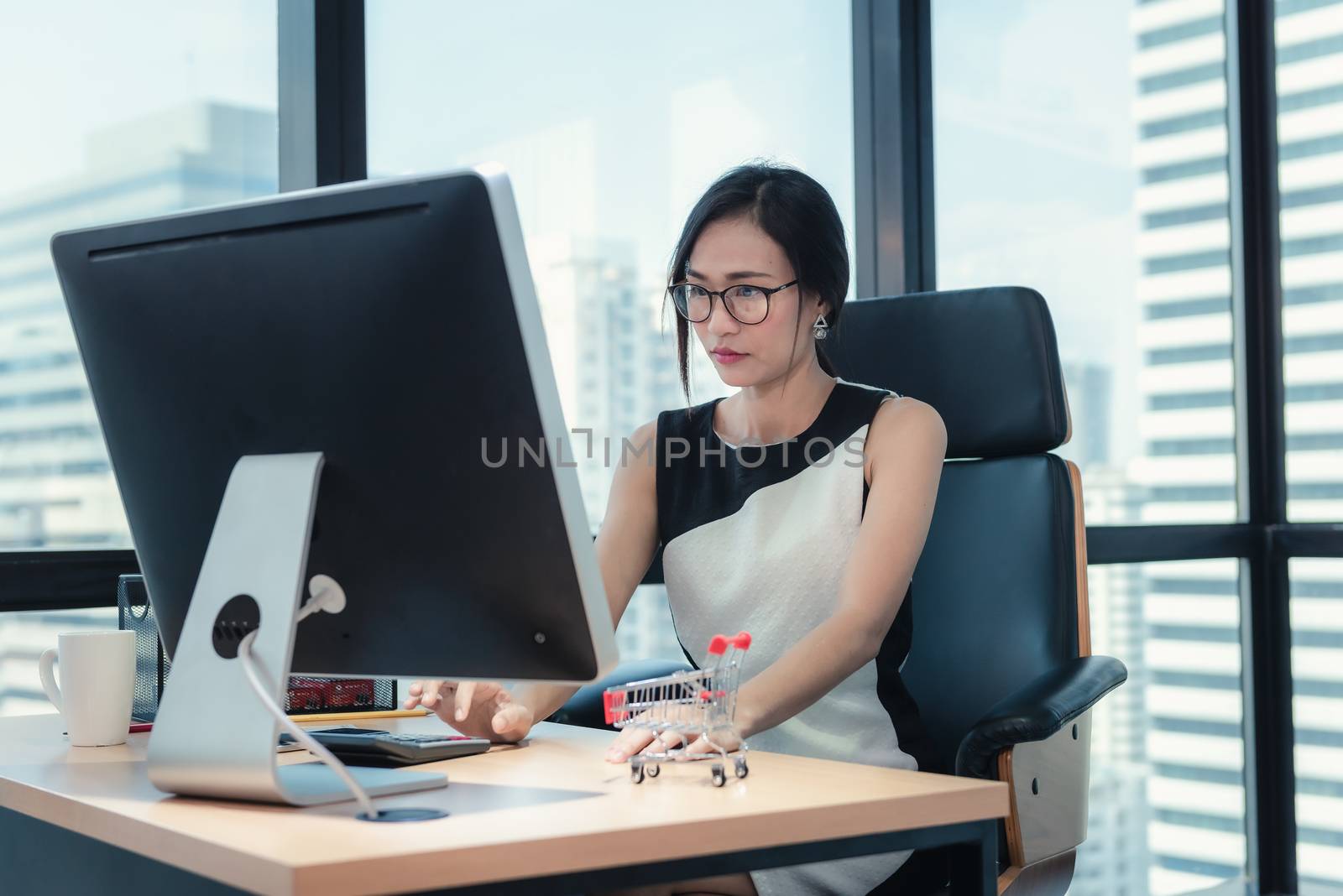 Business Woman Accountant is Woking on Her Table Desktop in Office Workplace, Attractive Beautiful Businesswoman is Concentrate at Paperwork Data and Analyzing on Database Accounting Company. by MahaHeang245789