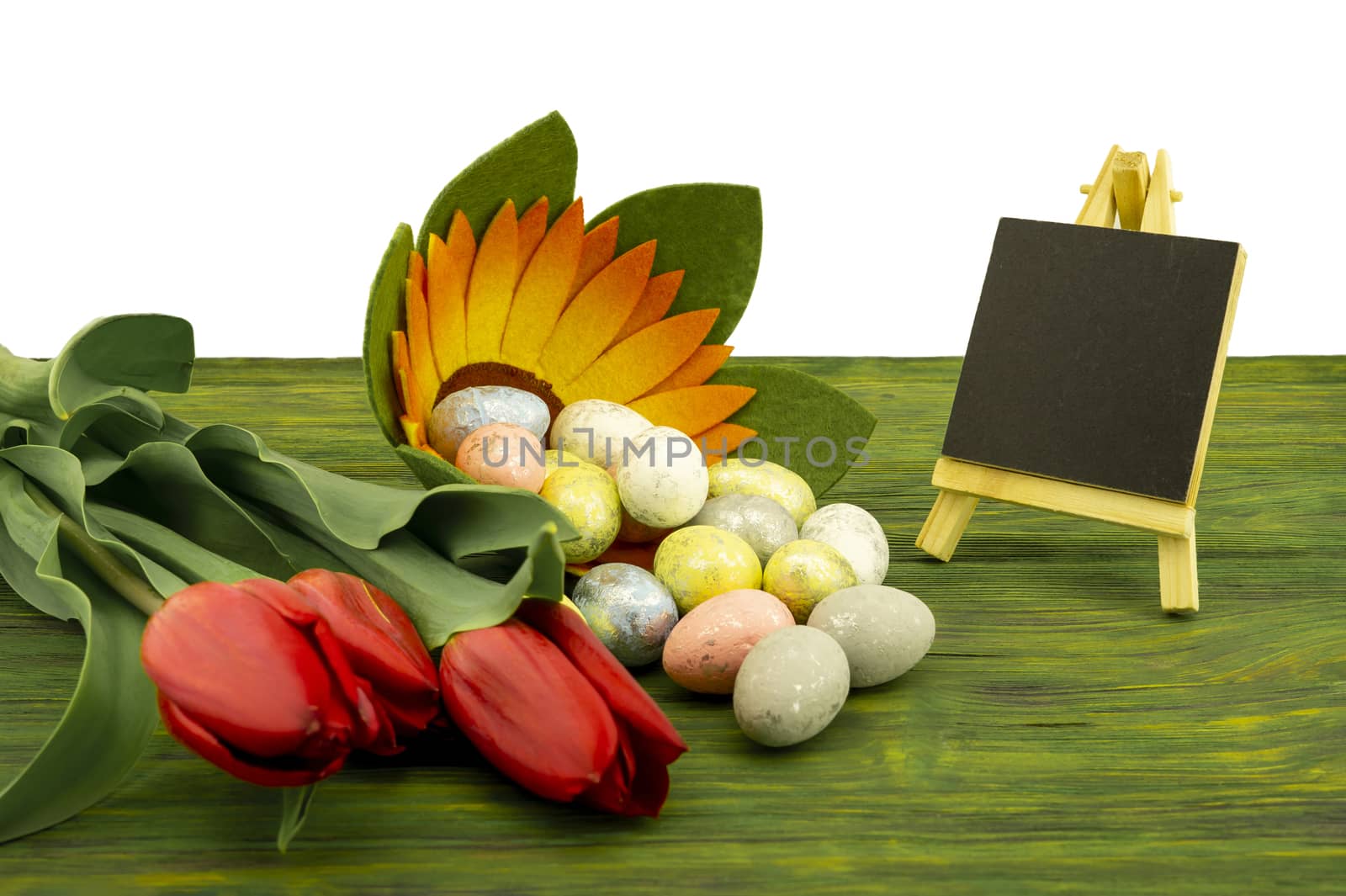 Easter background. Red spring tulips and painted eggs on vintage wooden board