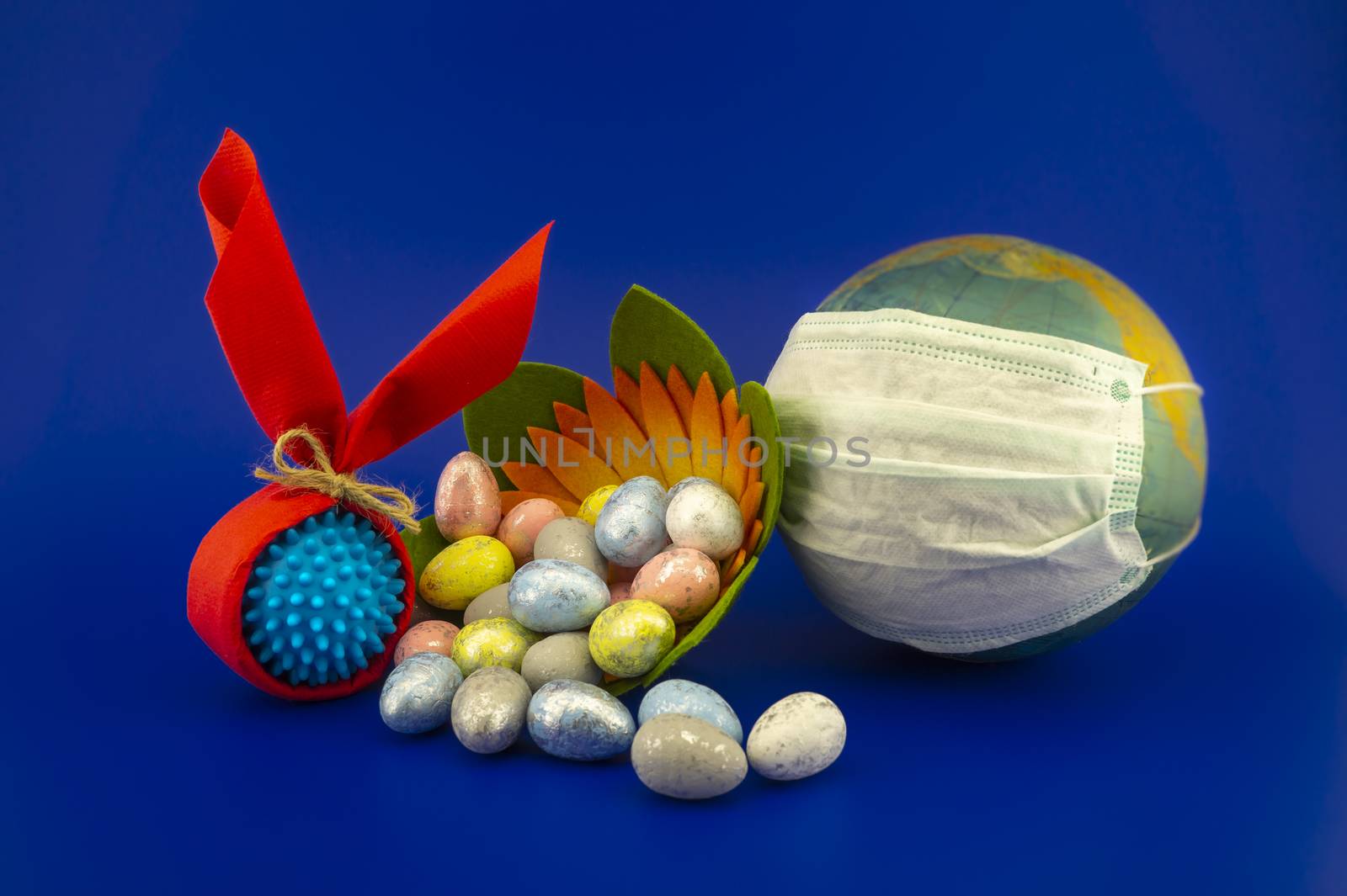 Easter eggs and corona virus models wrapped as gifts on a blue background with copy space.