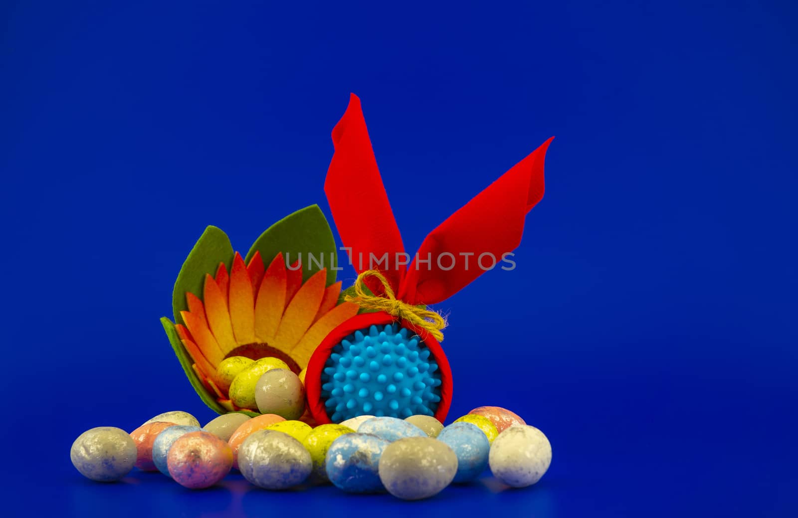 Close-up of Easter arrangement with eggs, flower and a Coronavirus or Covid-19 symbol on blue background for copy space