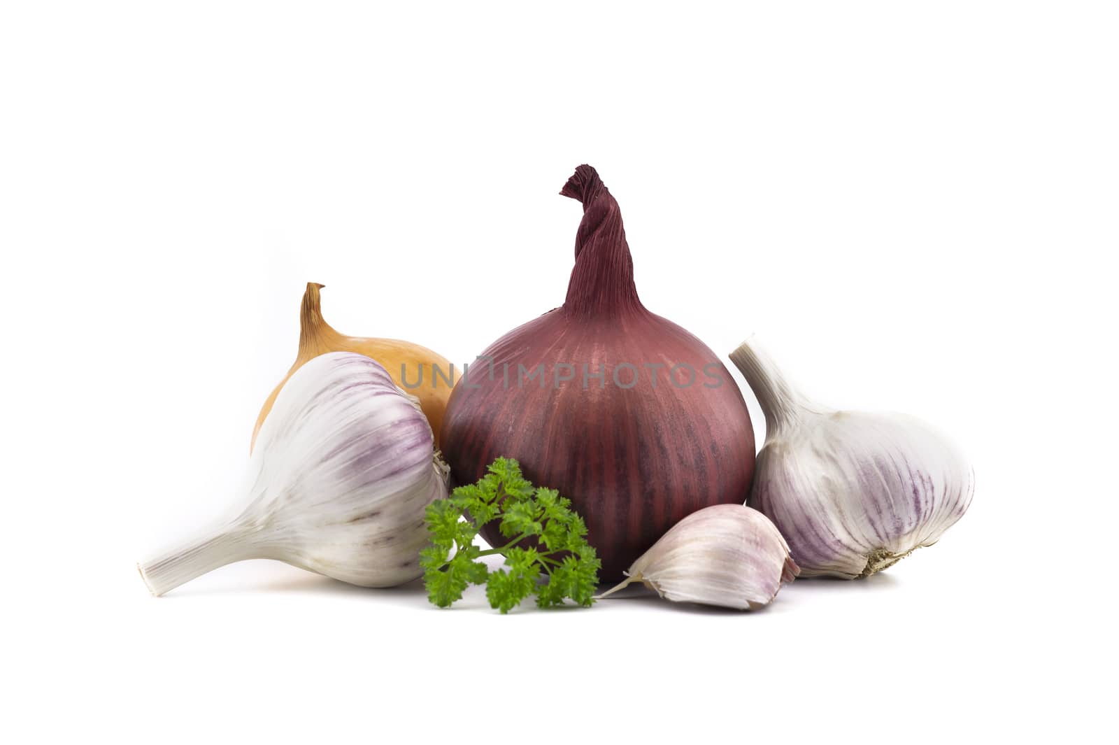 Garlic bulbs and cloves, green parsley twig, golden-brown and red onion isolated on white background